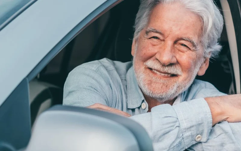 Conductor mayor de 70 años revisando su póliza de seguro de coche